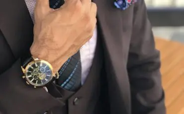 Man in formal suit jacket holding his necktie