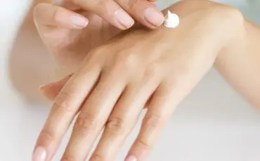 Woman applying lotion on hand